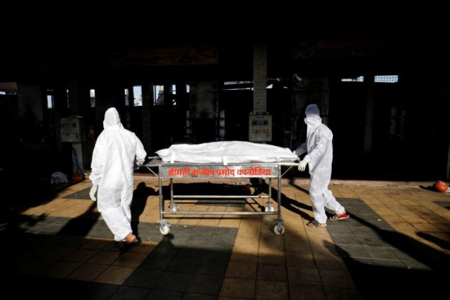 Workers move the body of a person who died from the coronavirus disease (Covid-19) for cremation inside the Kurukshetra crematorium in Surat, India on May 11, 2021 — Reuters/Files