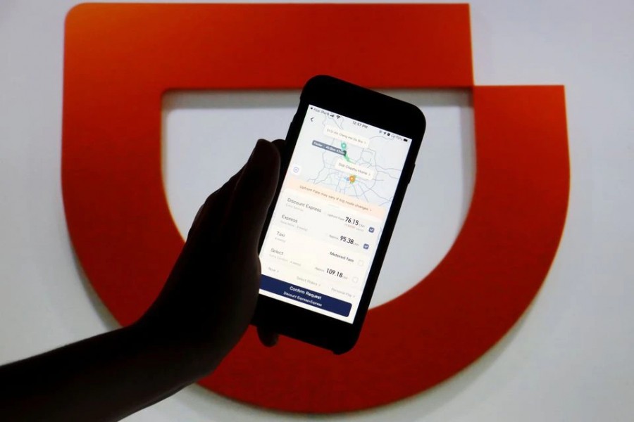 The app of Chinese ride-hailing giant Didi is seen on a mobile phone in front of the company logo displayed in this illustration picture taken on July 1, 2021 — Reuters/Files