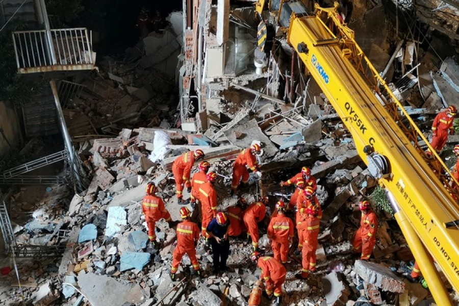 Rescue workers work next to a crane at the site where a hotel building collapsed in Suzhou, Jiangsu province, China July 12, 2021. Picture taken July 12, 2021. cnsphoto via REUTERS