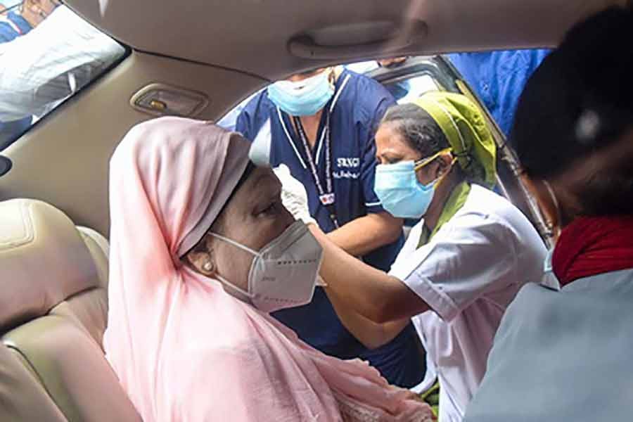BNP Chairperson Khaleda Zia taking her first dose of the coronavirus vaccine in his car at Sheikh Russel National Gastroliver Institute and Hospital in Dhaka on Monday -bdnews24.com photo