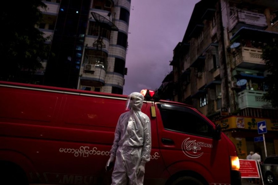 A medical staff wearing a protective suit stands near an ambulance, amid the outbreak of the coronavirus disease (COVID-19), in Yangon, Myanmar, September 27, 2020. REUTERS/Shwe Paw Mya Tin/File Photo