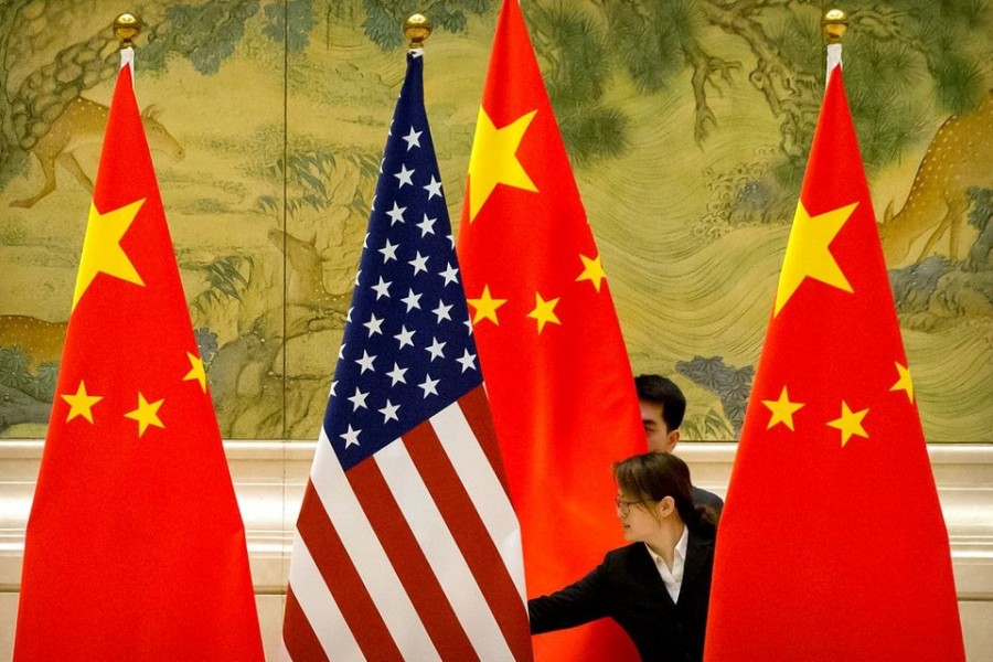 Chinese staffers adjust US and Chinese flags before the opening session of Sino-US trade negotiations in Beijing on February 14, 2019 — Pool via Reuters