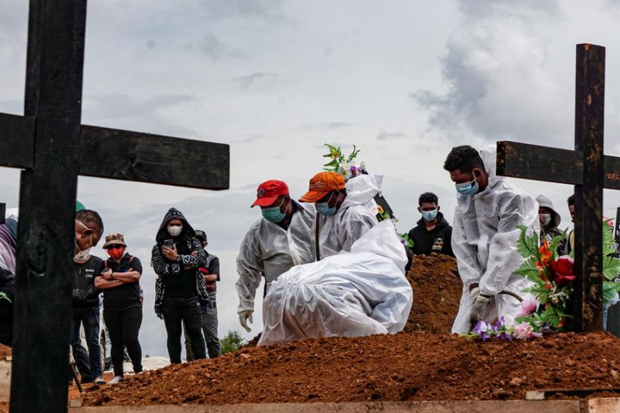 Gravediggers wearing personal protective equipment (PPE) burry a coffin at a burial area provided by the government for coronavirus disease (COVID-19) victims, as cases surge in Jayapura, Papua, Indonesia July 20, 2021, in this photo taken by Antara Foto/Indrayadi TH/via REUTERS