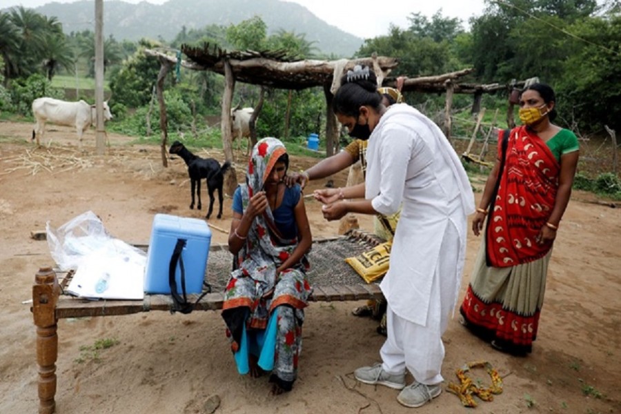 Healthcare worker Jankhana Prajapati gives a dose of the COVISHIELD vaccine against COVID-19, manufactured by Serum Institute of India, to villager Amiyaben Dabhi during a door-to-door vaccination drive in Banaskantha district in the western state of Gujarat, India, Jul 23, 2021. REUTERS