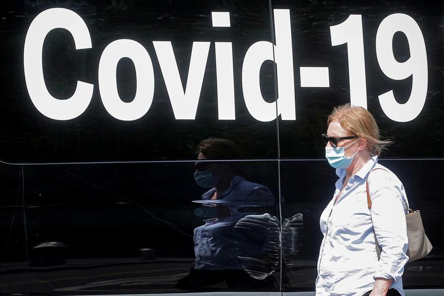 A woman wearing a mask passes by a coronavirus disease mobile testing van, as cases of the infectious Delta variant of Covid-19 continue to rise, in Washington Square Park in New York City, US on July 22, 2021 — Reuters/Files