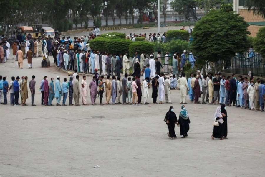 Residents line up to receive a vaccine against coronavirus disease (COVID-19) at a vaccination facility in Karachi, Pakistan, Aug 3, 2021. REUTERS/Akhtar Soomro