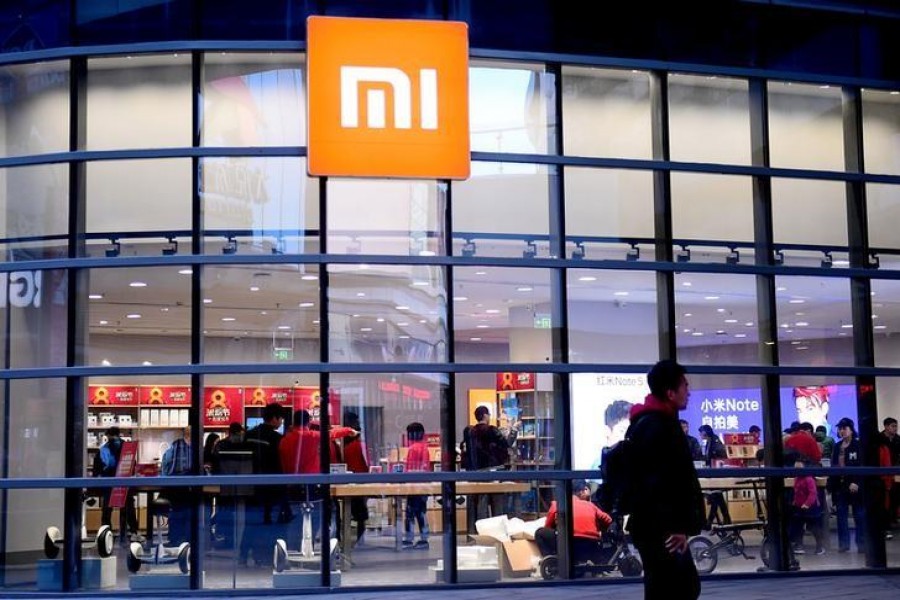 FILE PHOTO: A man walks past a Xiaomi store in Shenyang, Liaoning province, China April 7, 2018. Picture taken April 7, 2018. REUTERS/Stringer