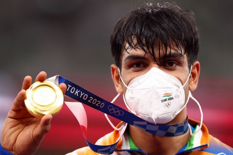 Tokyo 2020 Olympics - Athletics - Men's Javelin Throw - Medal Ceremony - Olympic Stadium, Tokyo, Japan - August 7, 2021. Gold medallist Neeraj Chopra of India on the podium while wearing a protective mask – Reuters