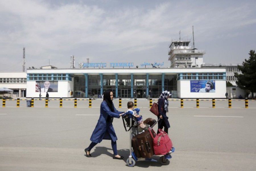 Afghan passengers walk in front of Hamid Karzai International Airport in Kabul, Afghanistan March 29, 2016 — Reuters/Files