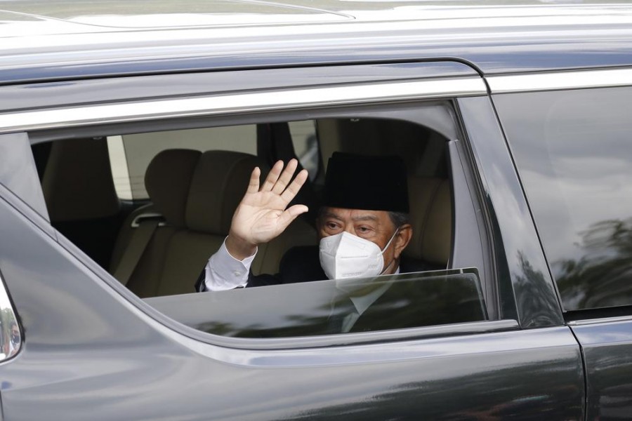 Embattled Malaysian Prime Minister Muhyiddin Yassin waves from a car while entering the National Palace to meet with the King in Kuala Lumpur, Malaysia, Monday, Aug. 16, 2021. (AP Photo/FL Wong)