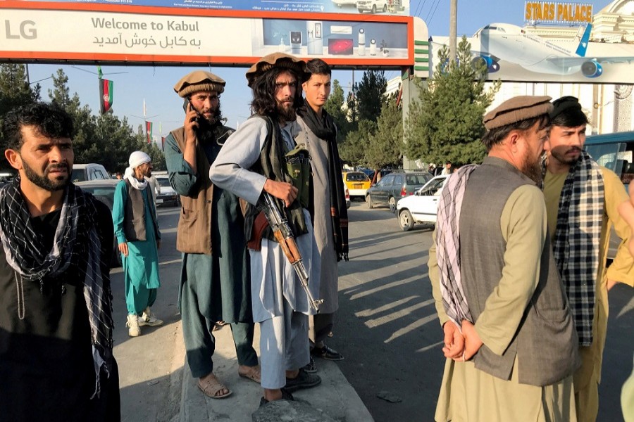 A member of Taliban (C) stands outside Hamid Karzai International Airport in Kabul, Afghanistan, August 16 — Reuters/Stringer