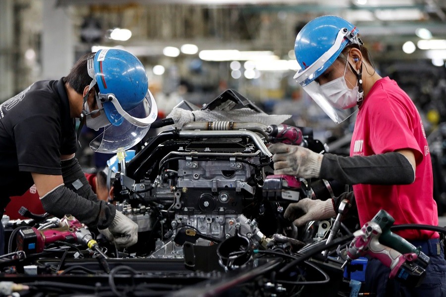 Employees wearing protective face masks and face guards work on the automobile assembly line, during the outbreak of the coronavirus disease (Covid-19), at Kawasaki factory of Mitsubishi Fuso Truck and Bus Corp., owned by Germany-based Daimler AG, in Kawasaki, south of Tokyo, Japan May 18, 2020 — Reuters/Files