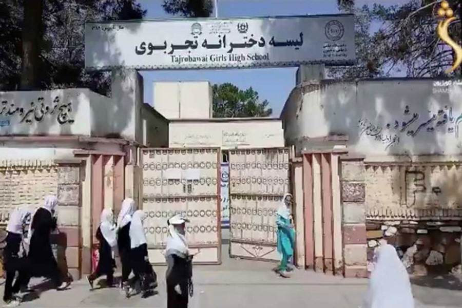 Afghan girls walk near the entrance of a school in the city of Herat, Afghanistan, in this still image taken from a video dated Aug 18, 2021. REUTERS