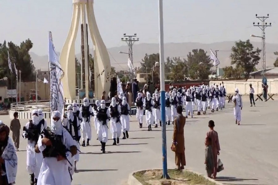 Taliban fighters march in uniforms on the street in Qalat, Zabul Province, Afghanistan, in this still image taken from social media video uploaded August 19, 2021 and obtained by REUTERS