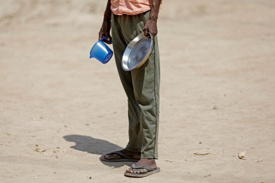 A daily wage labourer stands in a queue for free food at a construction site where activity has been halted due to 21-day nationwide lockdown to slow the spreading of the coronavirus disease (COVID-19), in New Delhi, India, April 10, 2020. REUTERS/Adnan Abidi