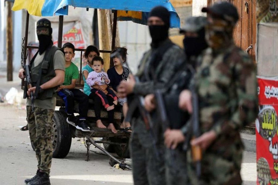 Palestinian children look on as Islamic Jihad militants stand guard following Israel-Hamas truce, in Gaza May 21, 2021 — Reuters/Files