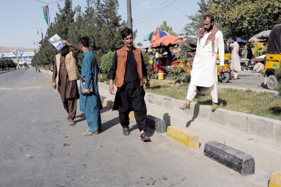 People walk on the street leading to the airport's Abbey gate where a blast occurred two days earlier, in Kabul, Afghanistan August 28, 2021. REUTER/Stringer