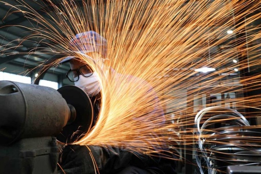 A worker wearing a face mask works on a production line manufacturing bicycle steel rim at a factory, as the country is hit by the novel coronavirus outbreak, in Hangzhou, Zhejiang province, China March 2, 2020. China Daily via REUTERS