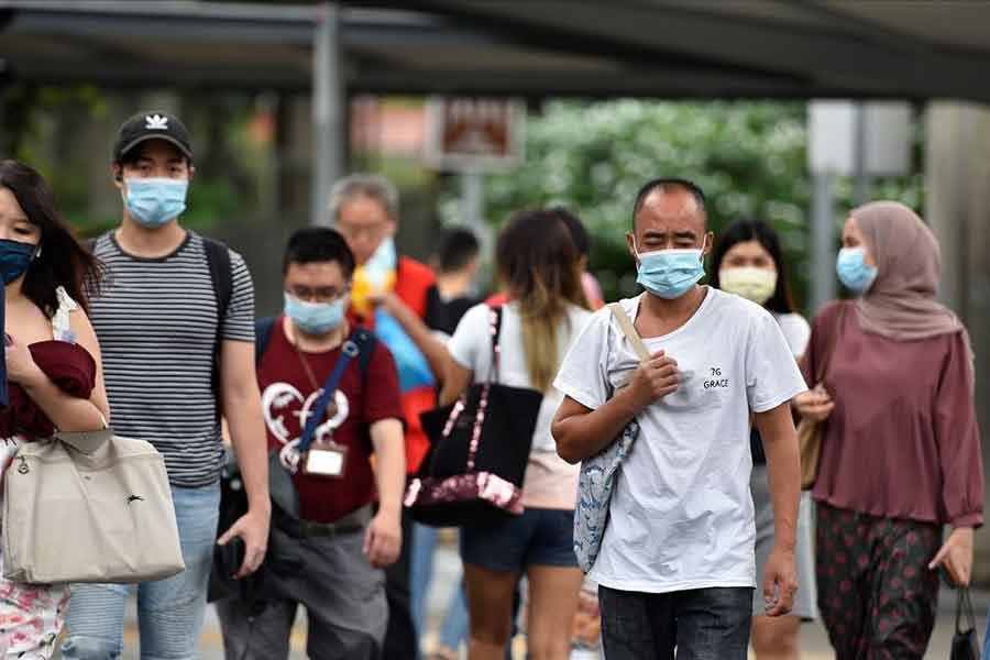 People wearing face masks crossing a road amid the coronavirus disease (COVID-19) outbreak in Singapore on May 14 this year -Reuters file photo