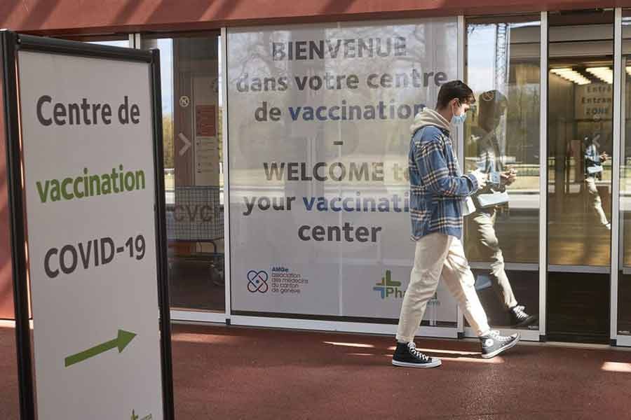 A man walking past a sign at a COVID-19 vaccination centre as the spread of the coronavirus disease (COVID-19) continues at the Palexpo in Geneva of Switzerland on April 15 -Reuters file photo