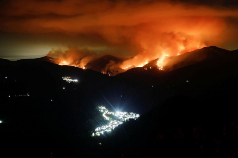 A wildfire is seen at night on Sierra Bermeja Mountain, near the towns of Genalguacil (L) and Benarraba (bottom), southern Spain, September 10, 2021. Picture taken with a long exposure. REUTERS/Jon Nazca