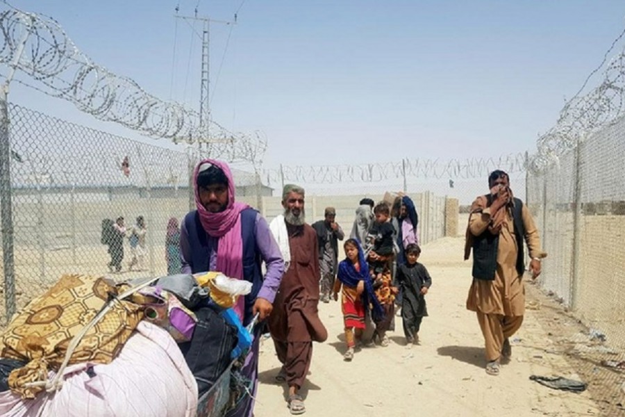 A family from Afghanistan walk next to fence to cross into Pakistan at the Friendship Gate crossing point, in the Pakistan-Afghanistan border town of Chaman, Pakistan September 6, 2021. REUTERS/Abdul Khaliq Achakzai