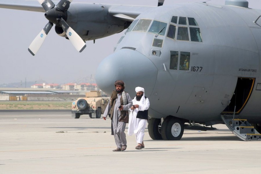 Taliban walk in front of a military airplane a day after the US troops withdrawal from Hamid Karzai International Airport in Kabul, Afghanistan August 31, 2021. REUTERS/Stringer