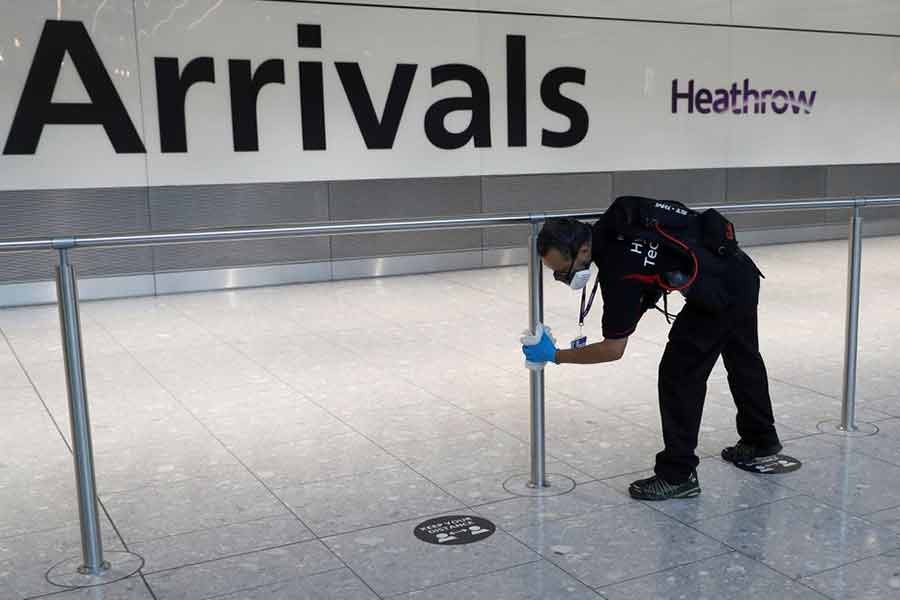 A worker sanitising a barrier at the international arrivals area of London's Heathrow Airport in Britain on August 2 this year -Reuters file photo