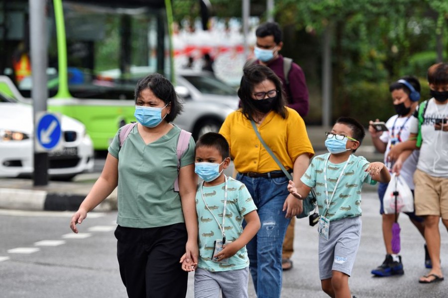 People wearing face masks cross a road amid the coronavirus disease (COVID-19) outbreak in Singapore May 14, 2021. REUTERS/Caroline Chia