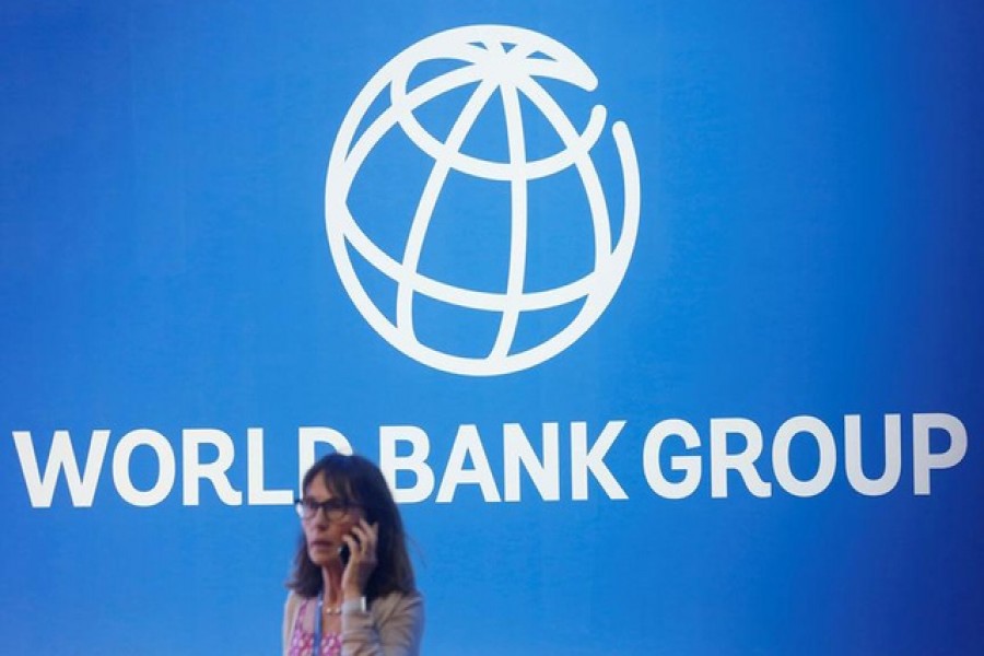 A participant stands near a logo of World Bank at the International Monetary Fund - World Bank Annual Meeting 2018 in Nusa Dua, Bali, Indonesia, October 12, 2018 — Reuters