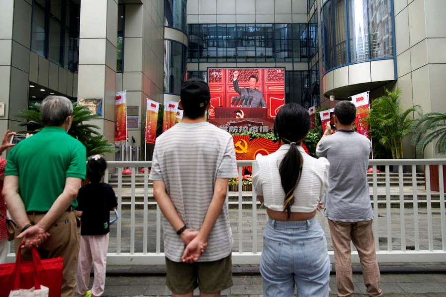 People watch a giant screen broadcasting Chinese President Xi Jinping's speech at a celebration marking the 100th founding anniversary of the Communist Party of China, in Shanghai July 1, 2021. REUTERS/Aly Song