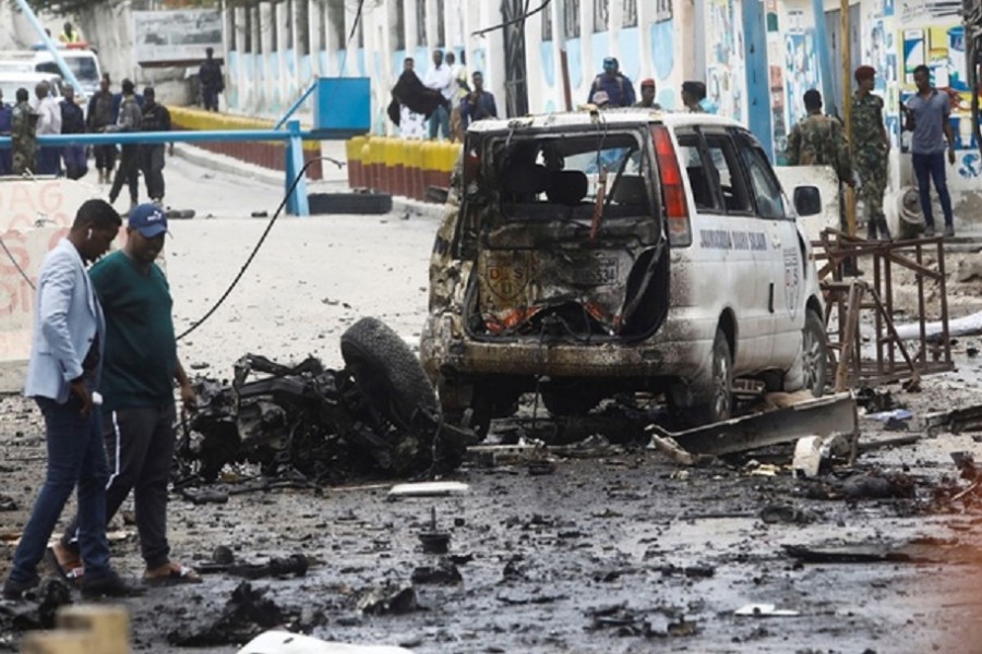 Civilians and Somalian security officers gather at the scene of a suicide car bomb at a street junction near the president's residence, in Mogadishu, Somalia, September 25, 2021. REUTERS/Feisal Omar