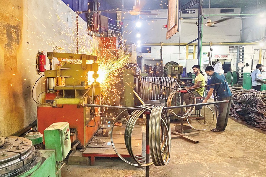 Workers making rims of bicycle tyres at a metal industrial unit at the BSCIC Industrial Estate of Jhumjhumpur in Jashore — FE photo