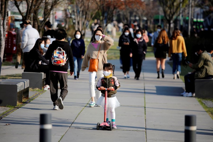 A girl wearing a protective face mask to prevent contracting the coronavirus disease (COVID-19) rides a toy kick scooter at a park in Seoul, South Korea, April 3, 2020. REUTERS/Heo Ran