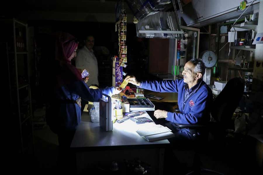 People shopping at a grocery store under a portable electric light during a power cut near Bhamdoun of Lebanon on Saturday –Reuters file photo