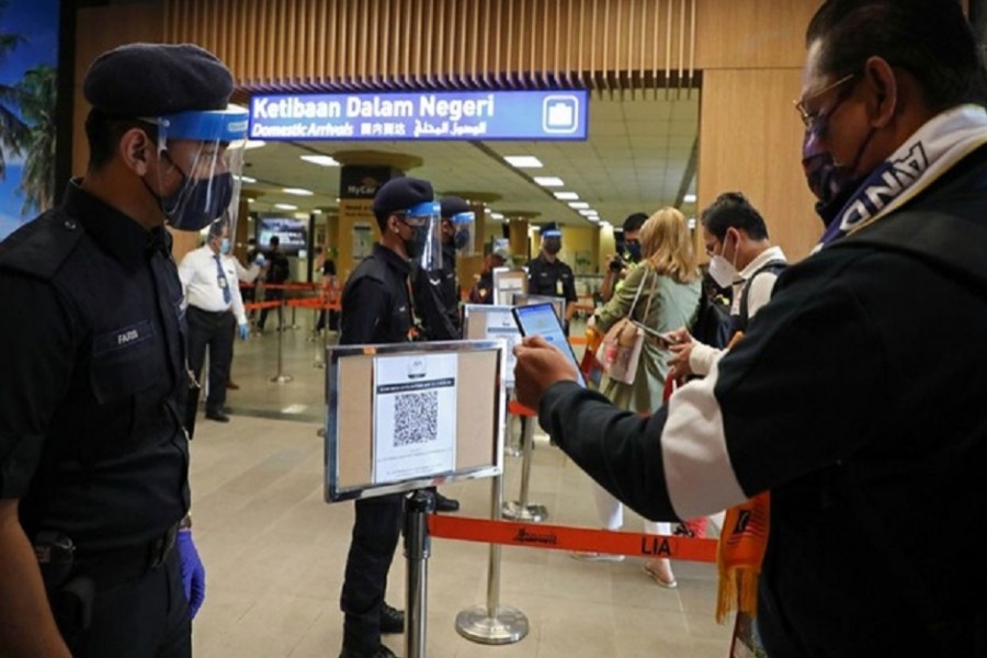 A tourist scans a QR code to check in upon arriving at the airport as Langkawi reopens to domestic tourists, amid the coronavirus disease (COVID-19) pandemic in Malaysia September 16, 2021. REUTERS/Lim Huey Teng