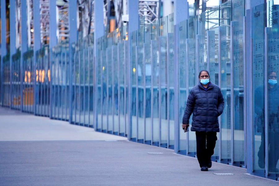 A woman wearing a protective face mask walks along a deserted city bridge during morning commute hours on the first day of a lockdown as the state of Victoria looks to curb the spread of a coronavirus disease (Covid-19) outbreak in Melbourne, Australia on July 16, 2021  — Reuters/Files