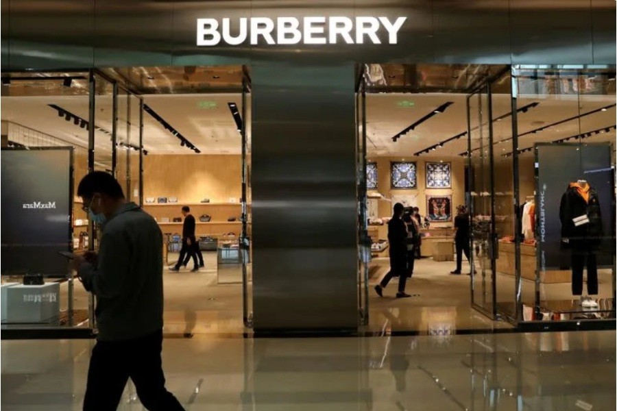 FILE PHOTO: Man walks past a Burberry store in Beijing