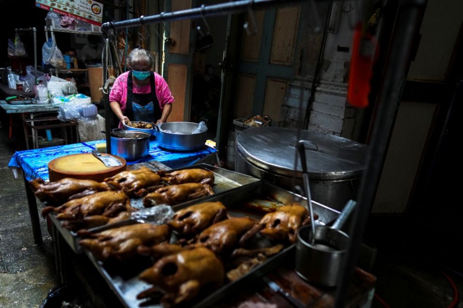 Janya Saetang, 55, a sister of Ladda Saetang who died at age 66 of the coronavirus disease (COVID-19) in May, during Thailand's worst wave of infections works next to pans of stewed ducks at her late sister's food stall in Bangkok's Chinatown, Thailand, October 4, 2021. Picture taken October 4, 2021. REUTERS/Athit Perawongmetha