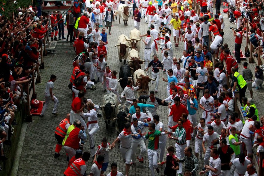 Runners sprint in front of Torrestrella fighting bulls at the entrance to the bullring during the first running of the bulls of the San Fermin festival in Pamplona July 7, 2014. REUTERS/Joseba Etxaburu/File Photo