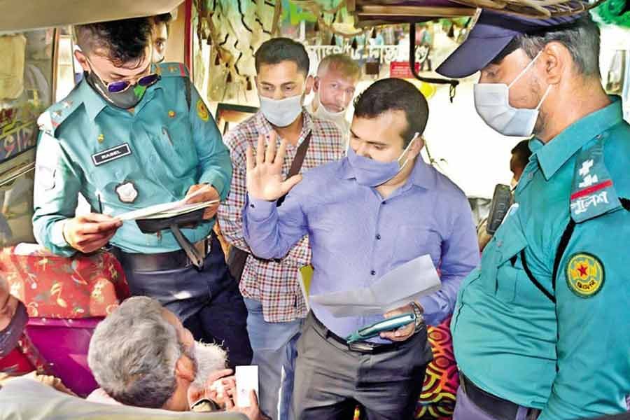 In the wake of allegations of charging higher fares than the agreed rates following a hike in diesel prices, an executive magistrate of the Dhaka Metropolitan Police talking to passengers of a bus while conducting a mobile court in front of the IDB Bhaban in the capital on Wednesday —Focus Bangla Photo