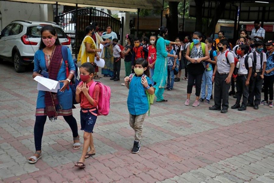 School students, wearing protective face masks, leave after attending their classes following the reopening of the primary schools after months of closure due to the coronavirus disease (COVID-19) outbreak in Ahmedabad, India, Nov 22, 2021. REUTERS/Amit Dave