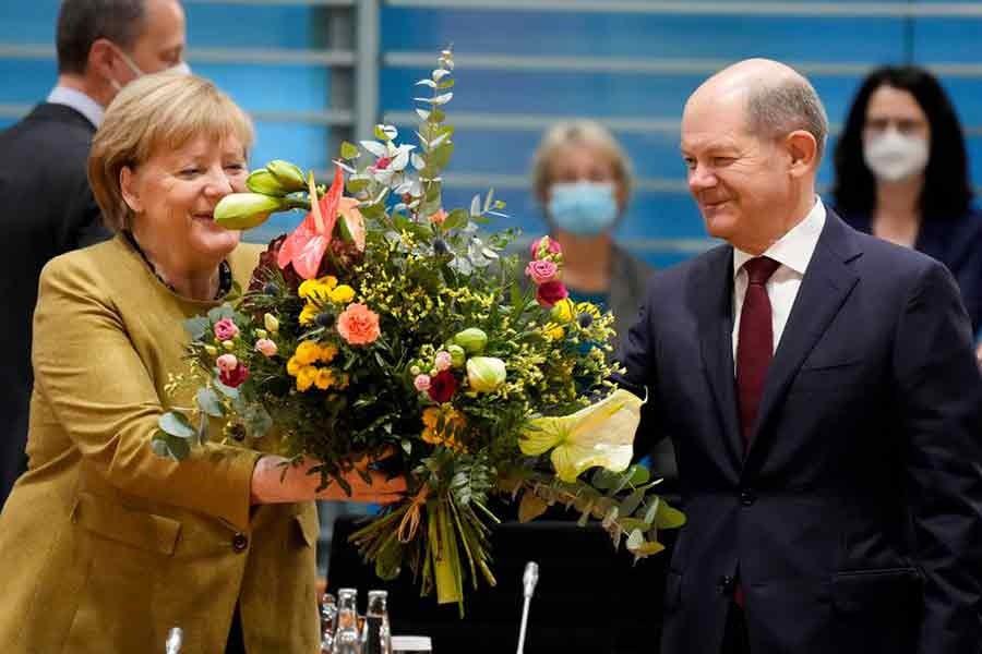 Acting German Chancellor Angela Merkel receiving a bouquet from acting German Finance Minister Olaf Scholz prior to the weekly cabinet meeting at the Chancellery in Berlin on Wednesday –Reuters file photo