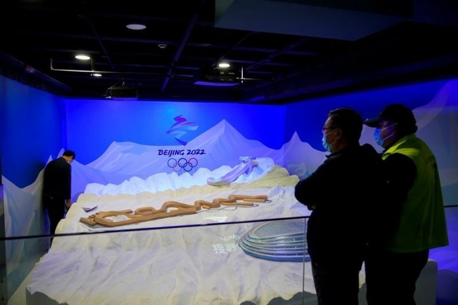 Staff members work near the emblem for Beijing 2022 Winter Olympics displayed at the Shanghai Sports Museum in Shanghai - Reuters