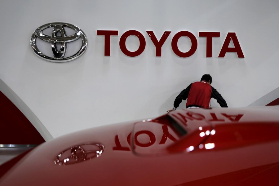 An employee works under a Toyota Motor Corp logo at the company's showroom in Tokyo, Japan February 5, 2016. REUTERS/Toru Hanai