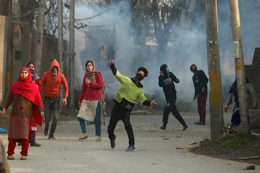 A demonstrator throws a stone towards Indian police (not pictured) during a protest following the killing of two suspected militants by Indian security forces in a gunfight in Rangreth on the outskirts of Srinagar Dec 13, 2021 – Reuters/Danish Ismail