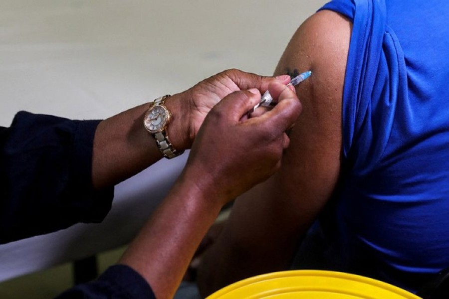 A healthcare worker administers the Pfizer coronavirus disease (COVID-19) vaccine to a man, amidst the spread of the SARS-CoV-2 variant omicron, in Johannesburg, South Africa, December 9, 2021. Reuters
