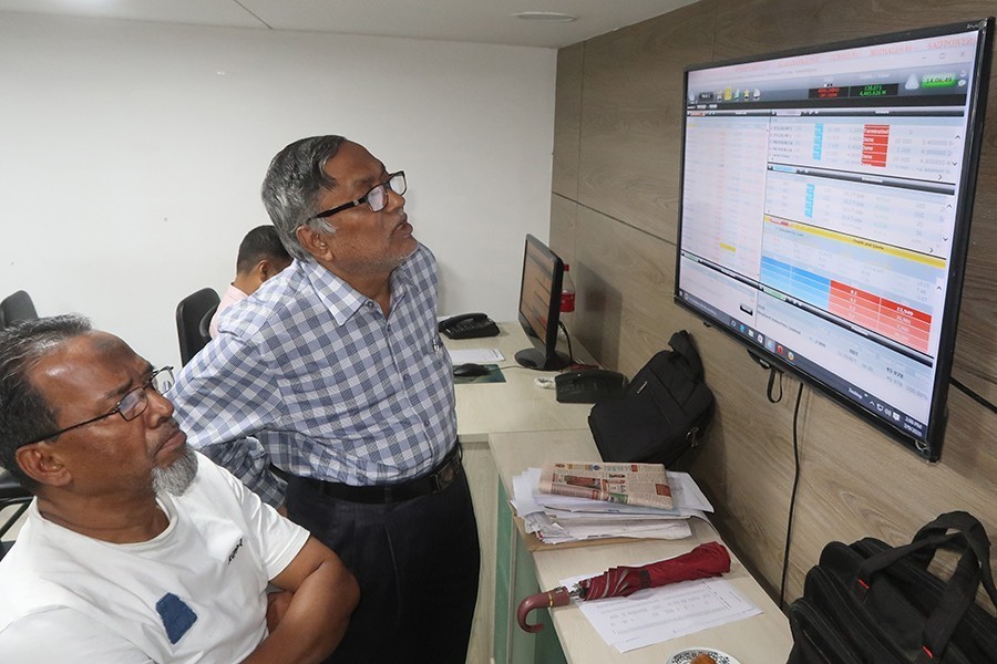 Investors react while monitoring stock price movements on TV and computer screens at a brokerage house in the capital city — FE/Files