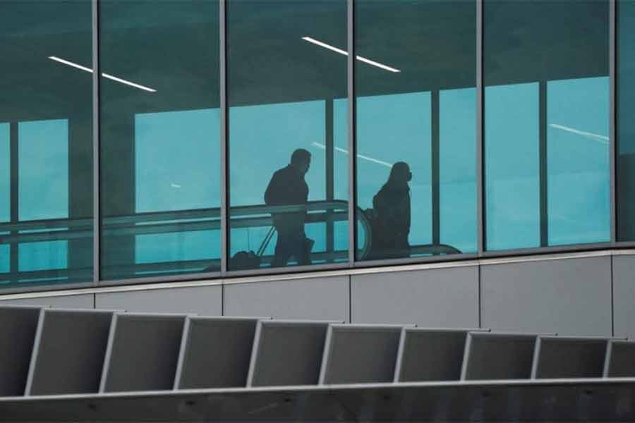 Travellers pulling luggage behind them inside Tom Bradley International Terminal at Los Angeles International Airport (LAX) in Los Angeles of California in the US on Wednesday as the coronavirus disease (COVID-19) Omicron variant threatens to increase case numbers during the holiday season -Reuters file photo