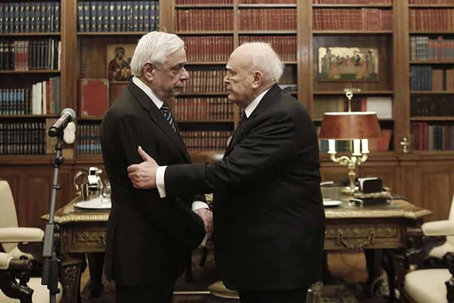 Outgoing Greek President Karolos Papoulias (R) shaking hands with newly-elected President Prokopis Pavlopoulos during a handover ceremony at the Presidential Palace in Athens -Reuters file photo